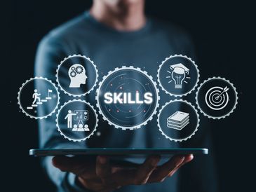 Digital gears showing various skills and development icons above a tablet.