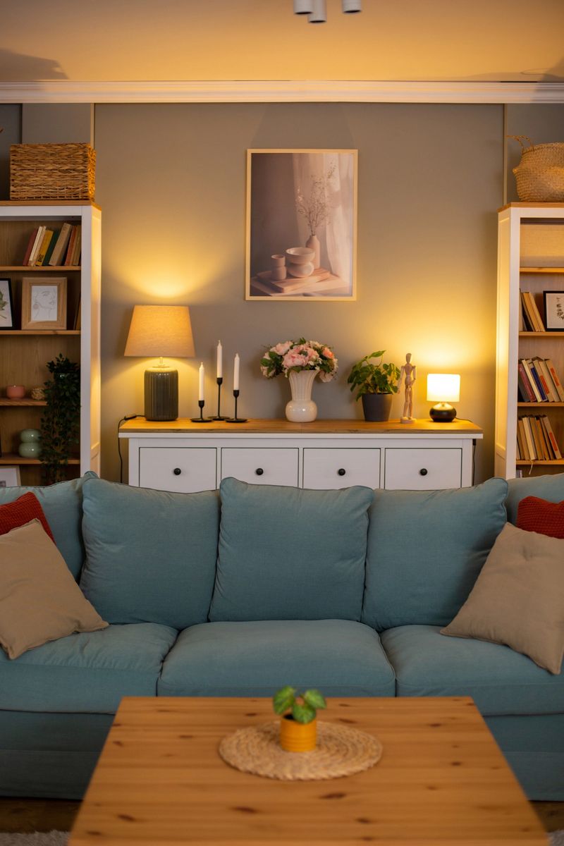 Warmly lit living room with comfortable sofa, bookshelves, and stylish decorations, creating a cozy and inviting atmosphere