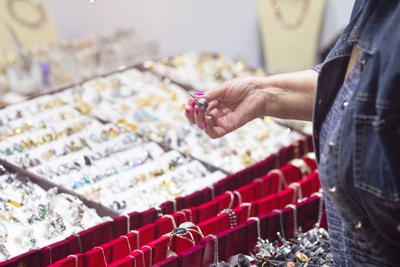 A woman chooses jewelry in a jewelry store. Sale