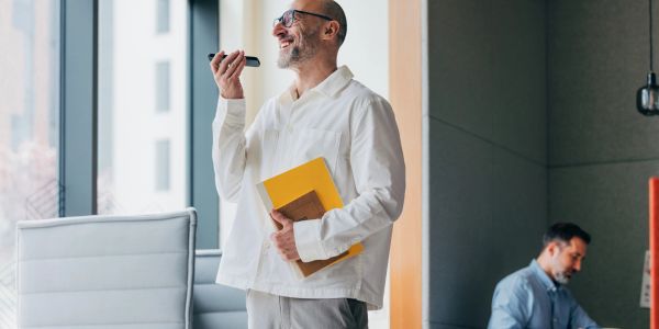 Man speaking into a voice recorder at work.