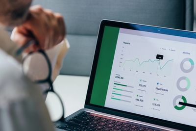 Person reviewing financial charts on laptop.