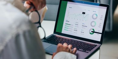 Person analyzing financial data on a laptop screen.
