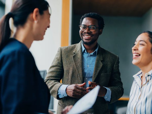 Business team discussing charts and graphs around a wooden table.
