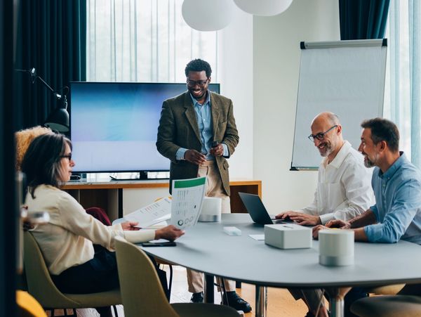 A diverse group of professionals engaged in a lively business meeting around a conference table.