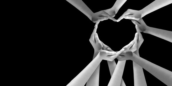 Peoples hands coming together to form a heart