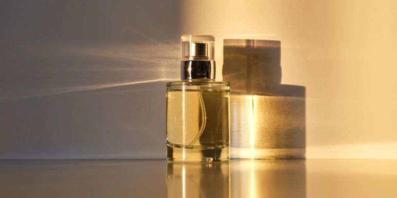 Perfume bottle casting shadows in warm light.