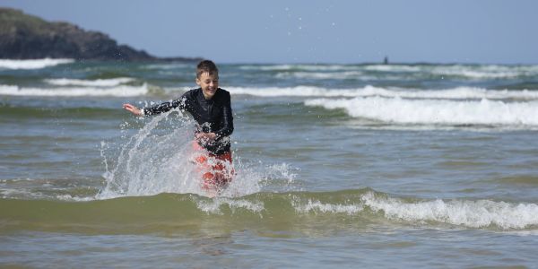 Boy playing in the ocean water.