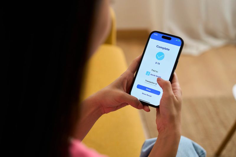 Woman using smartphone app to complete mobile payment transaction