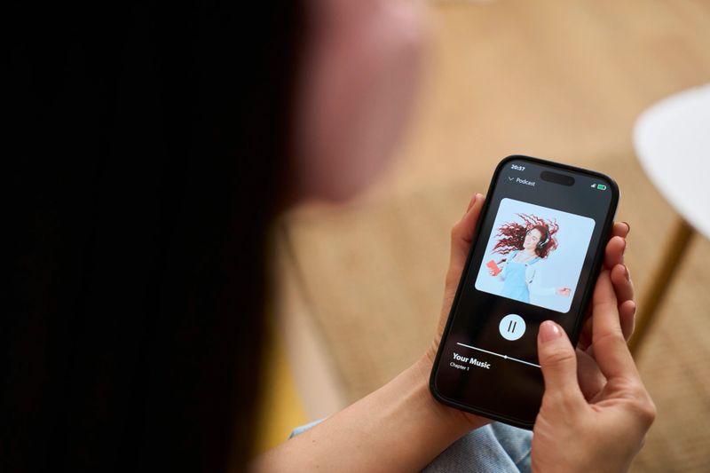 Young woman relaxing on the sofa at home listening to music on a mobile app