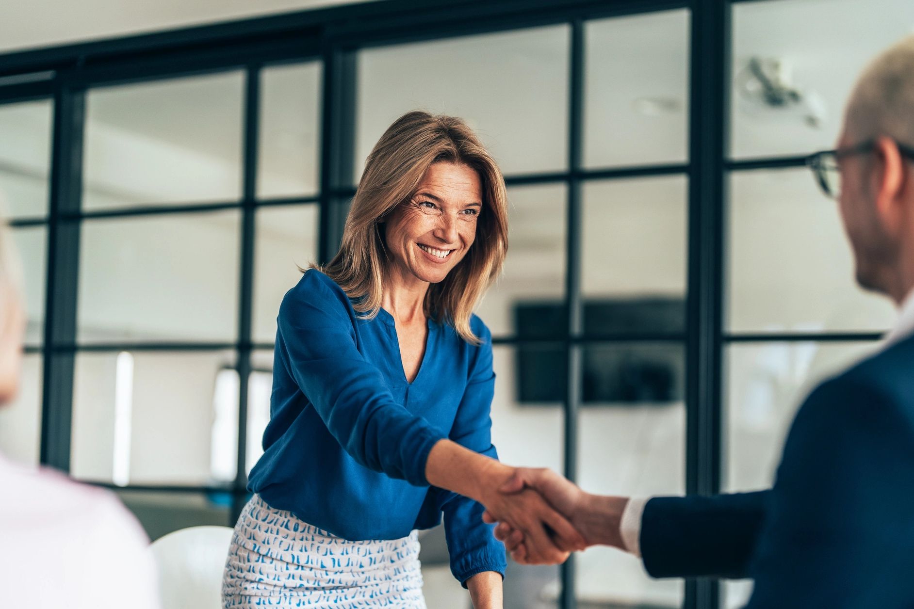 Businesswoman shaking hands in an office.