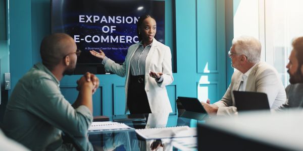 Businesswoman presenting e-commerce expansion to colleagues.