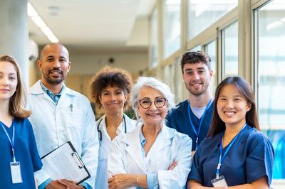 Diverse medical team posing confidently in hospital corridor.
