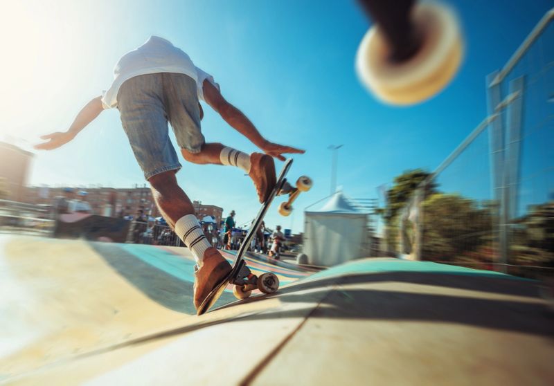 A young man performs dynamic maneuvers on a surfskate in a waveramp skate park. He rides the curves and edges with agility, dressed in casual summer attire. The photos capture the movement and energy of skate culture in an urban outdoor setting.