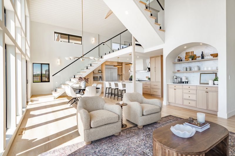 Interior rooms of an ocean front  home with floor to ceiling windows vaulted ceiling elegant spacious blue sky waterfront modern kitchen dining room entry foyer bedroom small home office area post and beam glass railing staircase loft bathrooms are white with marble granite and glass shower free standing bathtub modern appliances