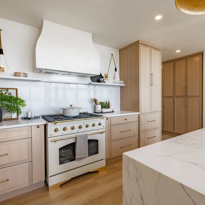 new kitchen with cabinets countertops range hood stove and flooring