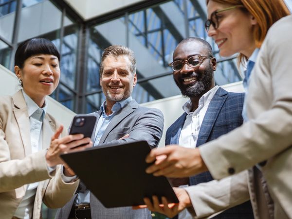 Diverse professionals collaborating with digital devices in a modern office.
