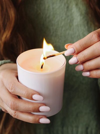 Lighting a candle with a match.