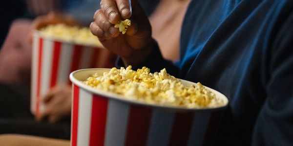 People enjoying popcorn in a movie theater setting.