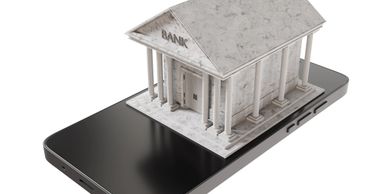A marble bank building model sits atop a smartphone, symbolizing mobile banking.