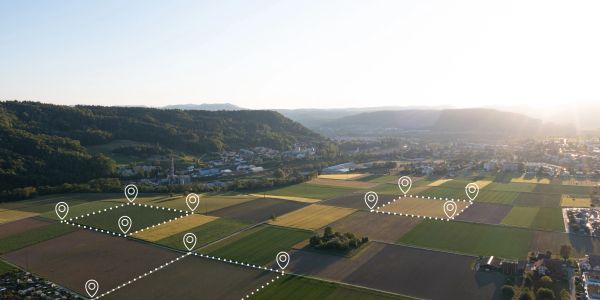 Aerial view of farmland with digital location markers and boundary lines.