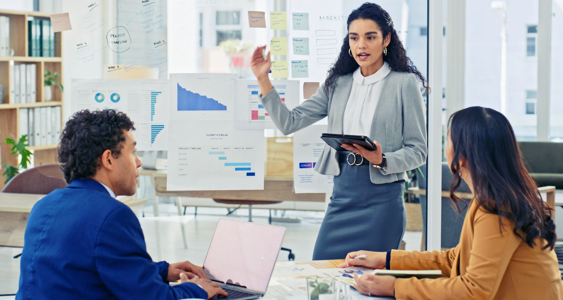 Stack of books next to pencils in a holder and a camera.