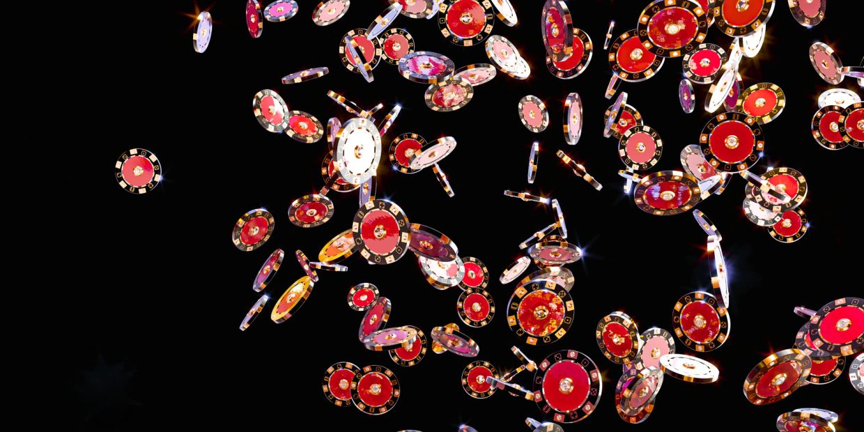 Colorful casino chips falling against a black background.