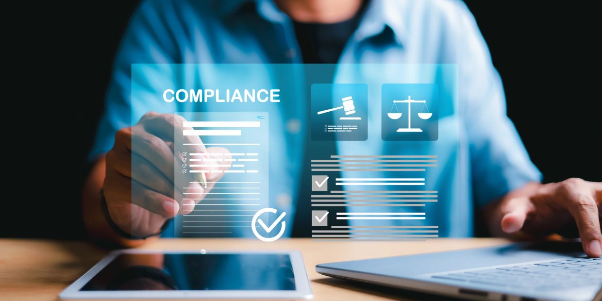 Person interacting with digital compliance and legal icons on a transparent screen.
