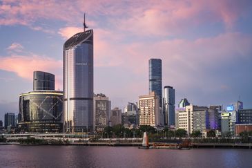 Skyline view of modern buildings during sunset by the water.