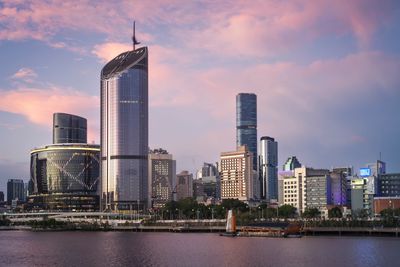 Skyline view of modern buildings during sunset by the water.
