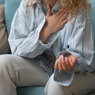 A woman smiling and talking on a video call from her cozy living room.
