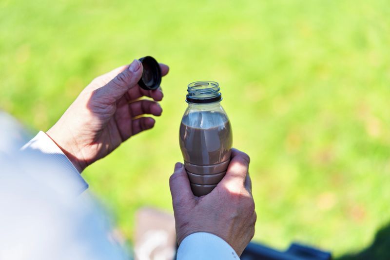 Drinking Coffee Latte from Recycled PET Plastic Bottle Outside