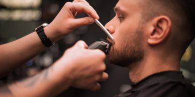 Man getting his beard trimmed at a barbershop.