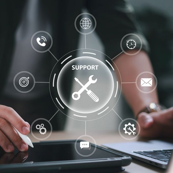 Digital support icons around a tablet and laptop.