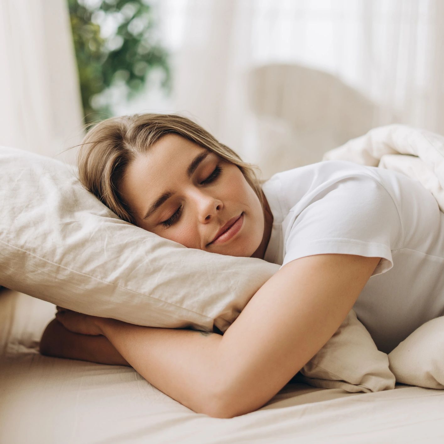 Woman sleeping peacefully in a bright, calm bedroom