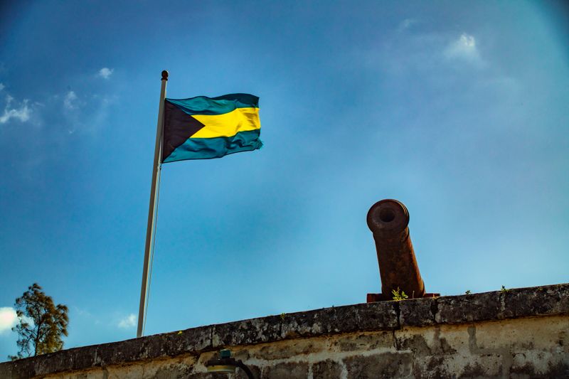 Cannon and the flag of the Bahamas at Fort Fincastle in Nassau, blue clear sky, sunshine.