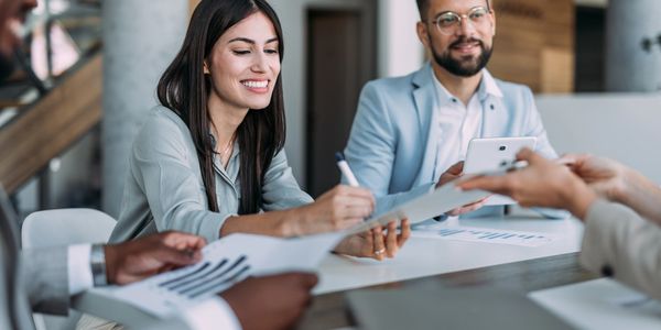 Business meeting with people reviewing documents and discussing.