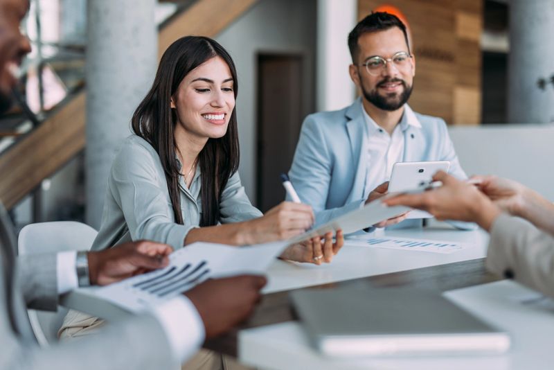 Shot of confident businesswoman filling in paperwork in an office. Business persons signing a document during a meeting in board room.
