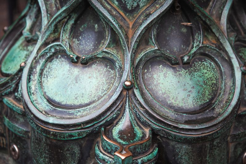 A striking bronze sculpture installed in a public park, showcasing intricate details and flowing forms.