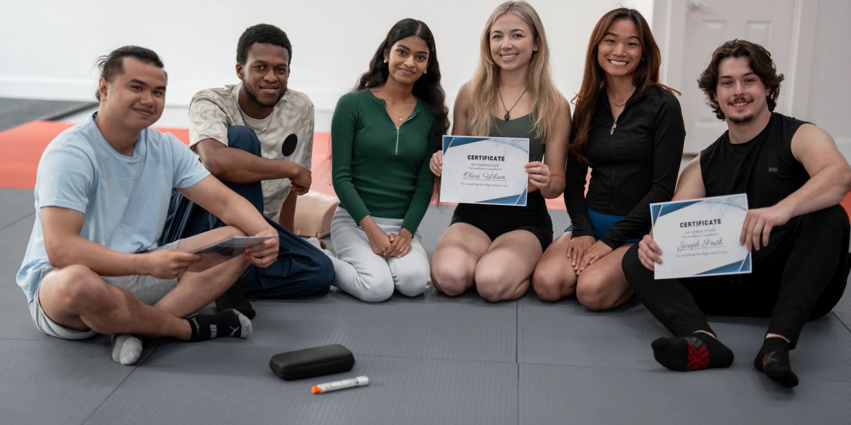 Grupo de jóvenes sentados mostrando certificados.