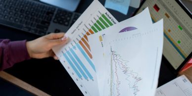 Person reviewing charts and graphs at a desk.