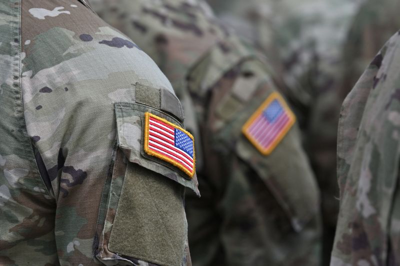 Person wearing military clothes with national symbol. USA flag on military uniform - close up shot