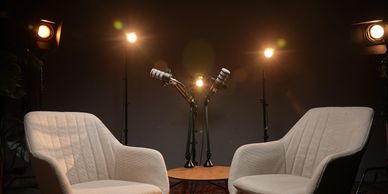 Podcast studio, podcast chairs, podcast microphones with studio lighting. 