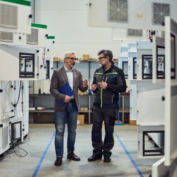 Two men discussing in a manufacturing facility.