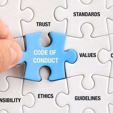 A group of puzzles with words. There is a blue puzzle piece with the words " Code of Conduct."