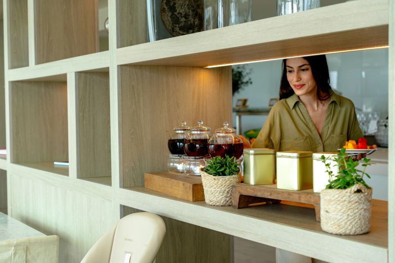 Young woman preparing a vibrant tray filled with tea and fresh fruit in a bright, modern kitchen, enjoying a moment of relaxation