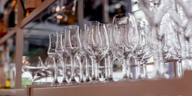 Rows of empty wine glasses on a shelf.