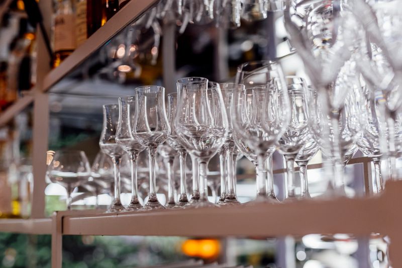 Romantically set dinner table with wine glasses and floral centerpiece, perfect for a wedding, elegant party, or outdoor evening celebration. Warm lights and soft bokeh create an intimate and luxurious atmosphere.