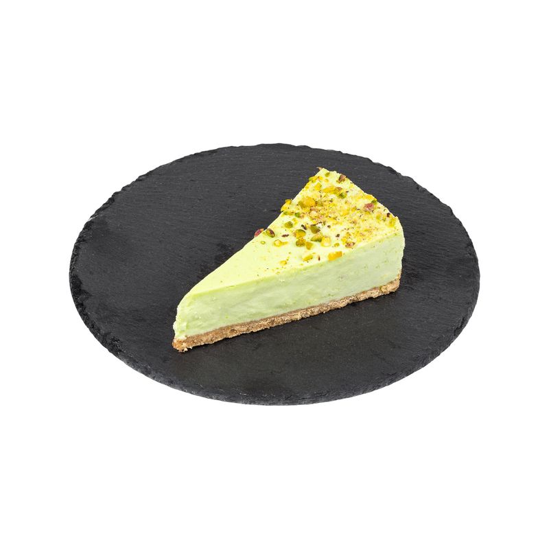 A slice of pistachio cheesecake on a black slate plate, featuring a creamy texture, nutty topping, and elegant presentation.