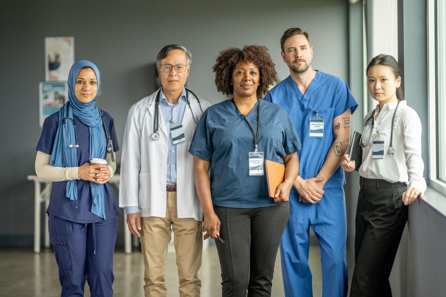 Diverse group of healthcare professionals standing together in a hospital hallway.