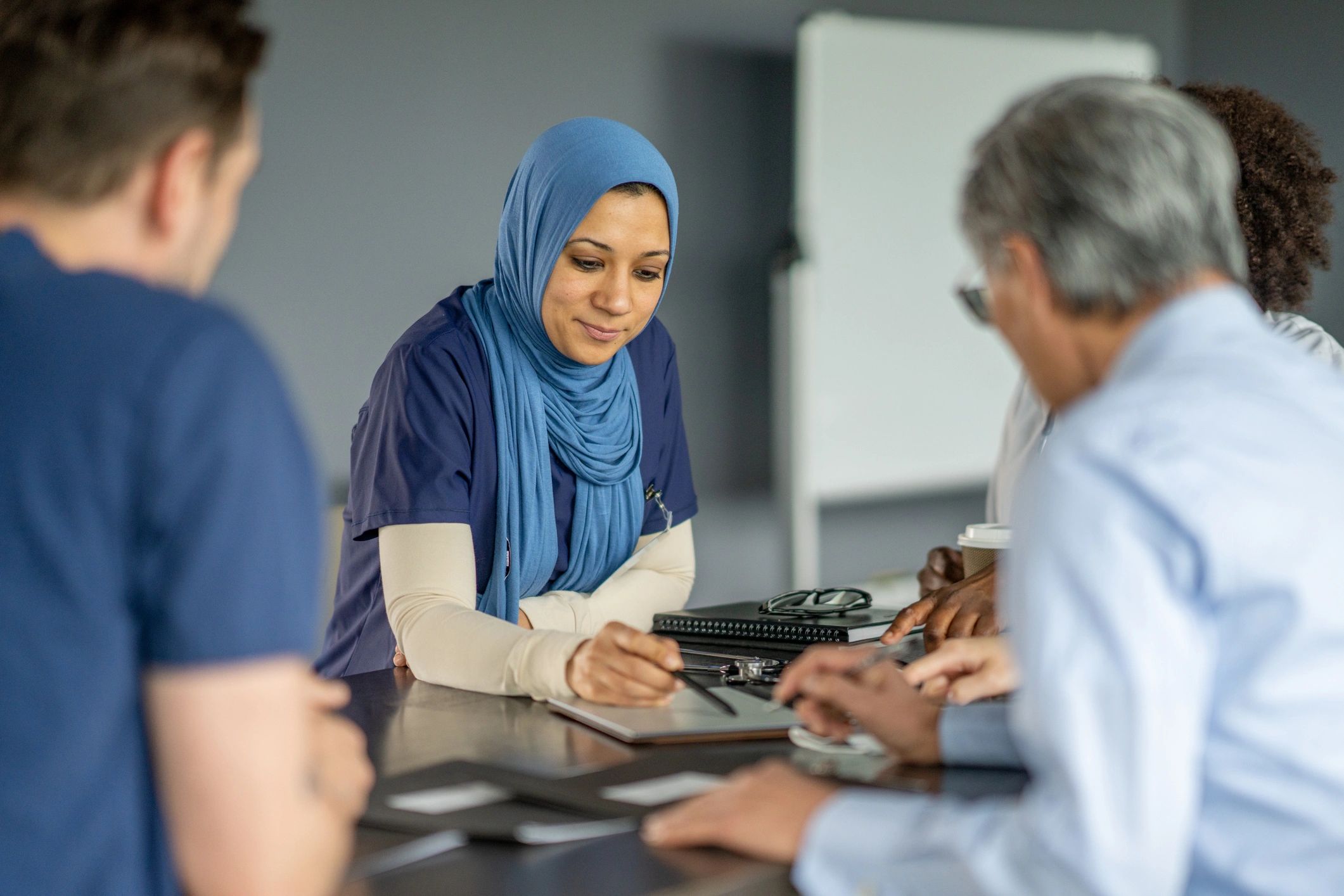 Medical professionals discussing patient care around a table.